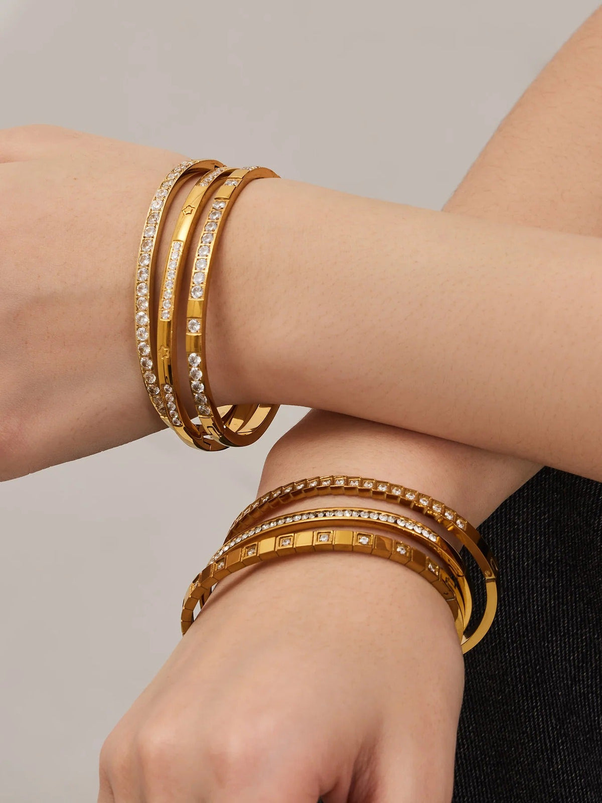 Gold bangles stacked on wrists