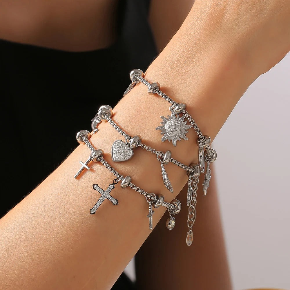Silver charm bracelets stacked on wrist