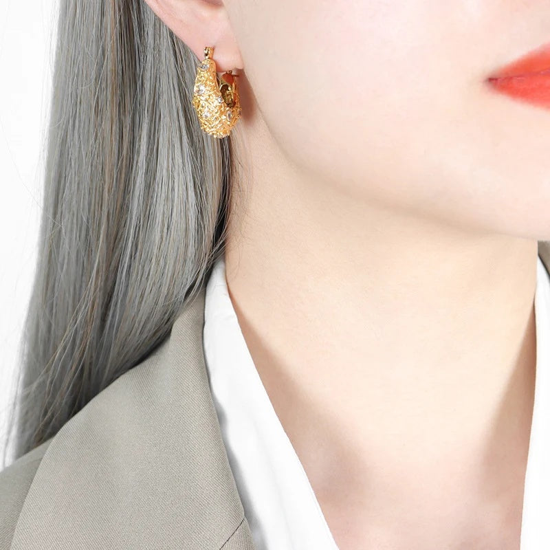Gold Stardust Hoops worn on the ear