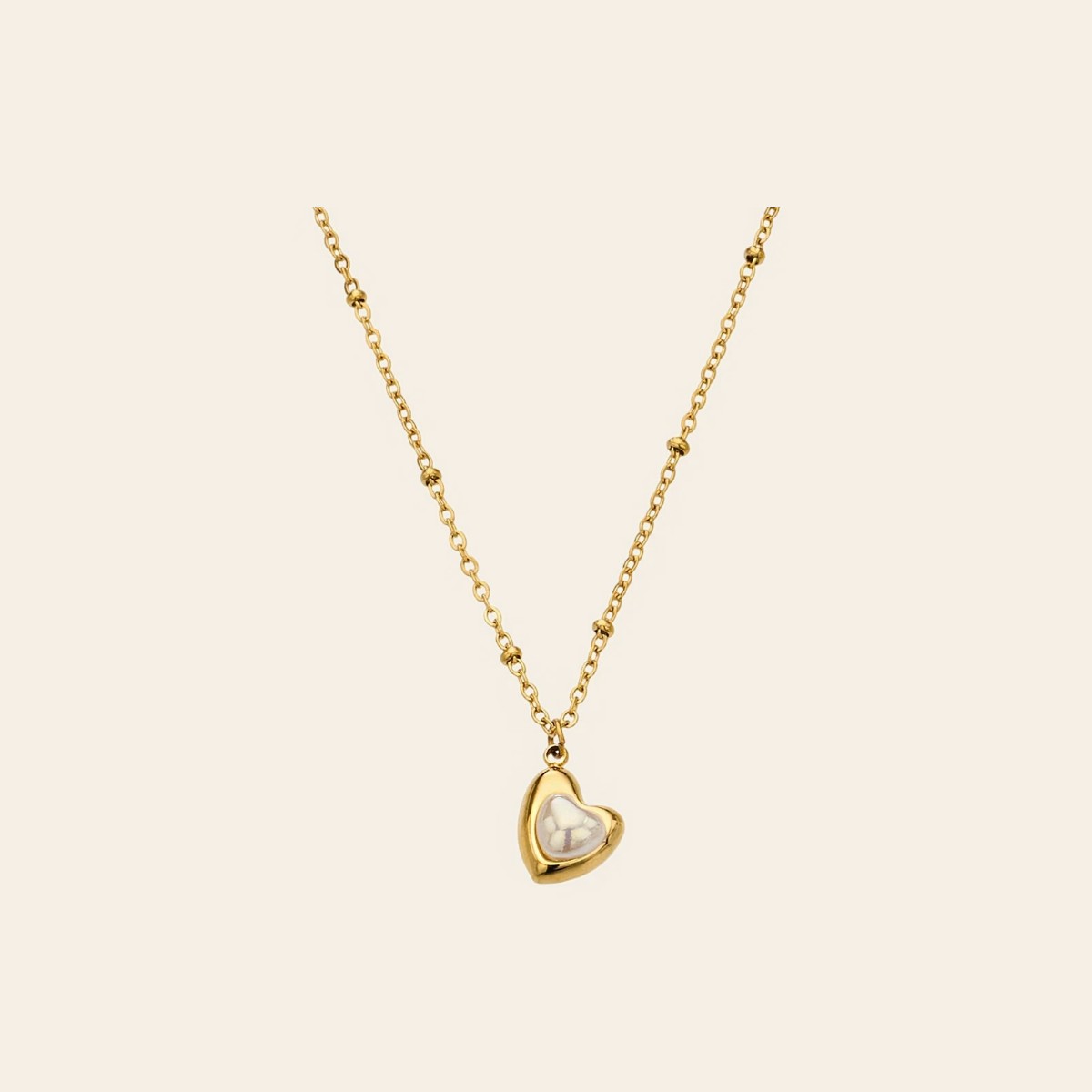 The Sweetheart Necklace, a pearly heart pendant on a gold satellite chain
